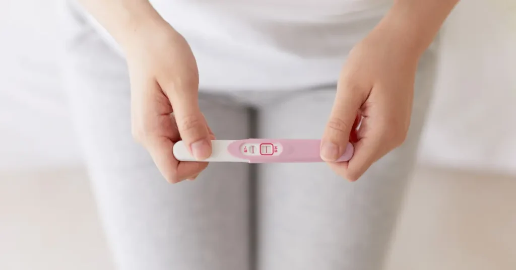 Mujer sosteniendo prueba de embarazo, haciendo referencia a hábitos de fertilidad