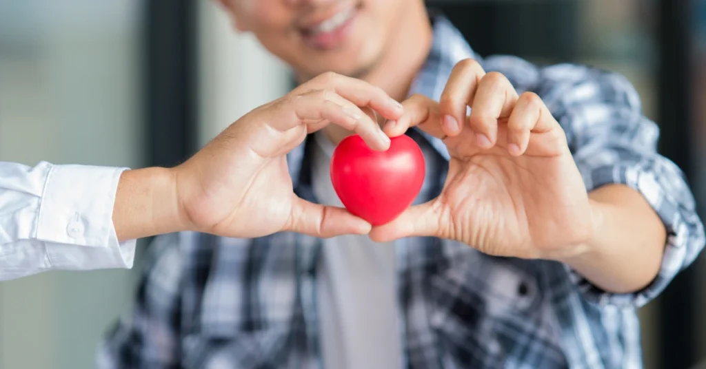 Medico y paciente sosteniendo un corazón rojo, haciendo alusión al arttículo 10 hábitos saludables para un corazón fuerte y una vida sana