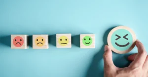 Dibunos de diferentes caras sobre sellos de madera en colores que van del rojo al azul y de la tristeza a la alegria, haciendo alución a 5 técnicas de relación para el manejo del estrés