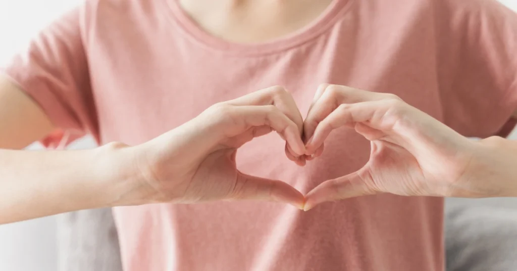 Mujer haciendo la forma de un corazón sobre su pecho, haciendo alución al articulo COFAR salud cardiovascular, la guía definitiva para entender tu corazón