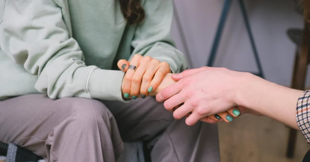 Amigas tomadas de las manos una brindandoles apoyo emocional a la otra, haciendo alución a enfermedades mentales comunes sintomas y tratamientas para un bienestar pleno