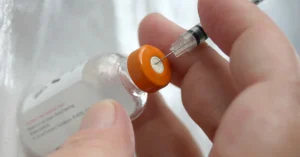 Persona sacando Insulina de su viál con una jeringa, haciendo referencia al artículo nsulina 101 guia indispensable para conocer entender su rol en tu cuerpo