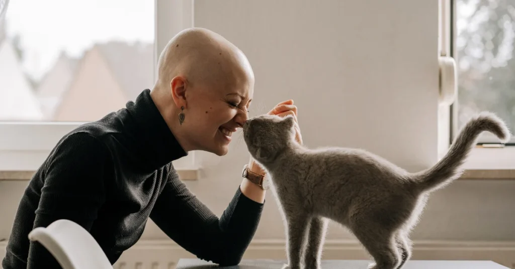 Mujer sobreviviente de Cancer jugando con su gato haciendo referencia al artículo Cual es el tipo de cancer más frecuente en chile?