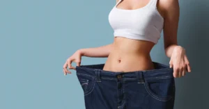 Mujer mostrando lo grande que le queda su antiguo pantalon hanciedo referencia al articulo 2 Tipos de Entrenamiento para Bajar de Peso: El Método Más Eficaz