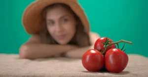 Mujer viendo tomates cherry, haciendo referencia a 3 Pilares del Concepto Esencial del Déficit Calórico: Qué es y Cómo Aplicarlo