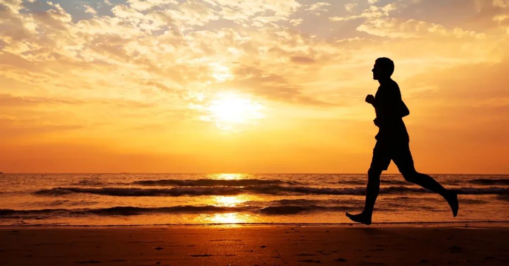 Hombre corriendo en la playa al atardecer, haciendo referencia al artículo 5 Claves para un Cambio Transformador: Mantener el Peso Ideal para Siempre
