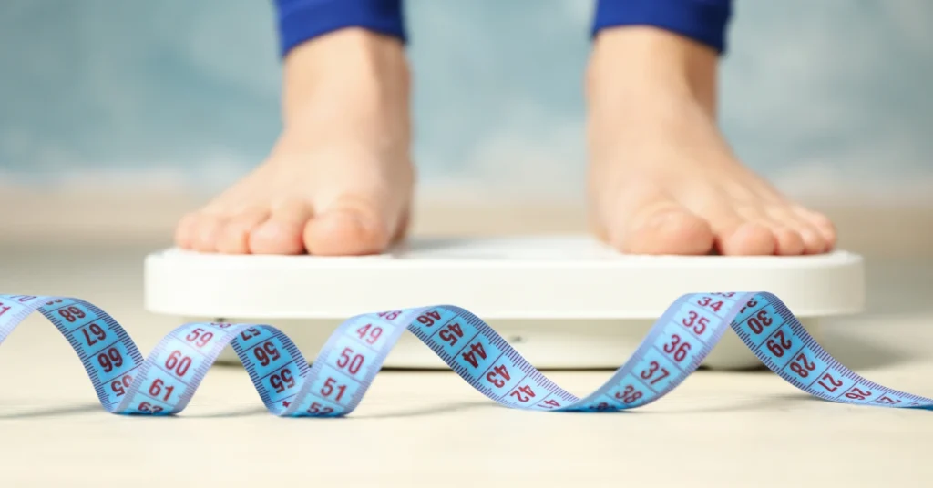 Persona sobre una balanza en referencia al blog 5 Detalles Esenciales que debes conocer de Mounjaro (Tirzepatida): El medicamento de Doble Acción para la Diabetes y el Control de Peso