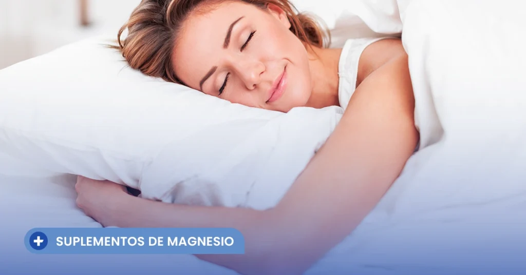 Mujer joven durmiendo profundamente y con una sonrisa serena en su cama, reflejando los beneficios positivos de la relación entre el magnesio y el descanso para combatir el estrés diario.