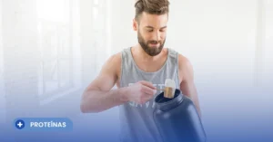 Hombre joven en ropa deportiva sacando una medida con el dosificador de su envase de suplemento, ilustrando los pasos iniciales sobre cómo tomar proteína en polvo de forma correcta y segura.