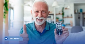 Un hombre mayor sonriente sentado en su hogar, sosteniendo un glucómetro digital que muestra una lectura de '4.8' y levantando el pulgar en señal de aprobación. En la esquina inferior izquierda, un banner azul con el logo de Cofar y el texto 'DIABETES' contextualiza el valor de glucosa normal en adultos.